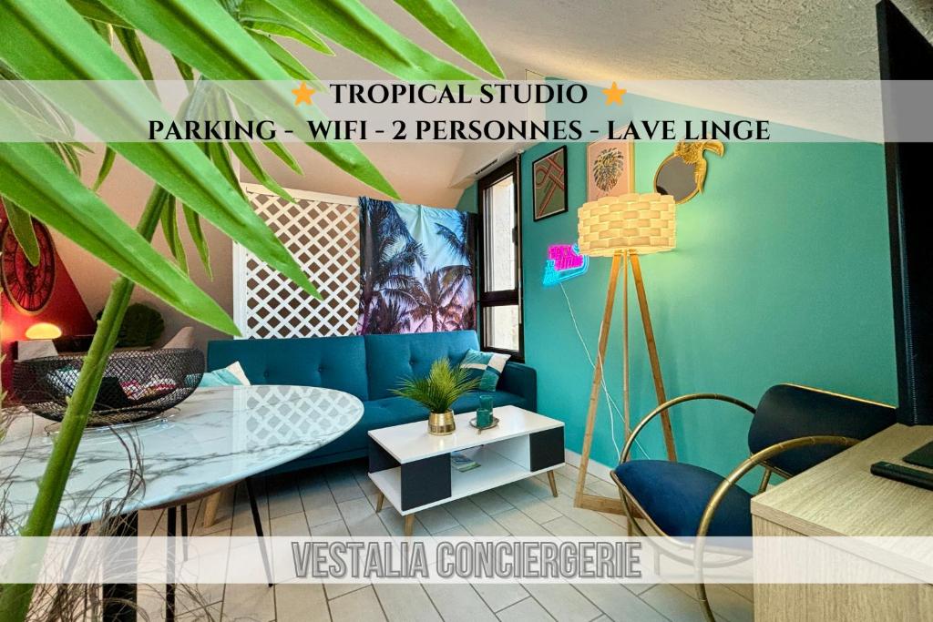 un soggiorno con divano blu e tavolo di -Tropical Studio- Paisible Parking Wifi Lave-Linge a Quimper