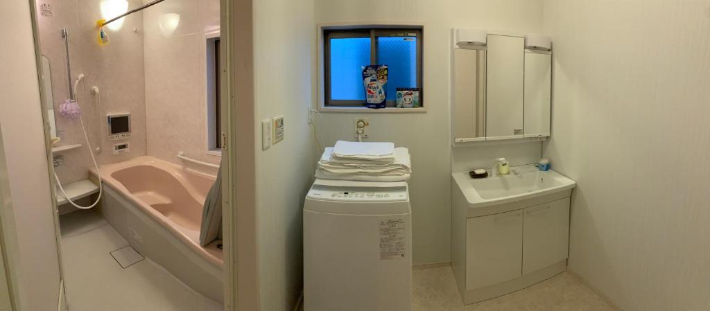 e bagno con lavandino, servizi igienici e vasca. di 孔雀民宿 ad Osaka