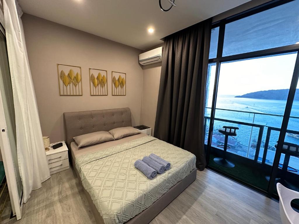 a bedroom with a bed and a large window at Seaview Designer Concept The shore Kota Kinabalu Sabah by UsHomestay in Kota Kinabalu