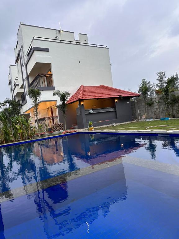 a house with a swimming pool in front of a building at Hidden beach stay in Chennai