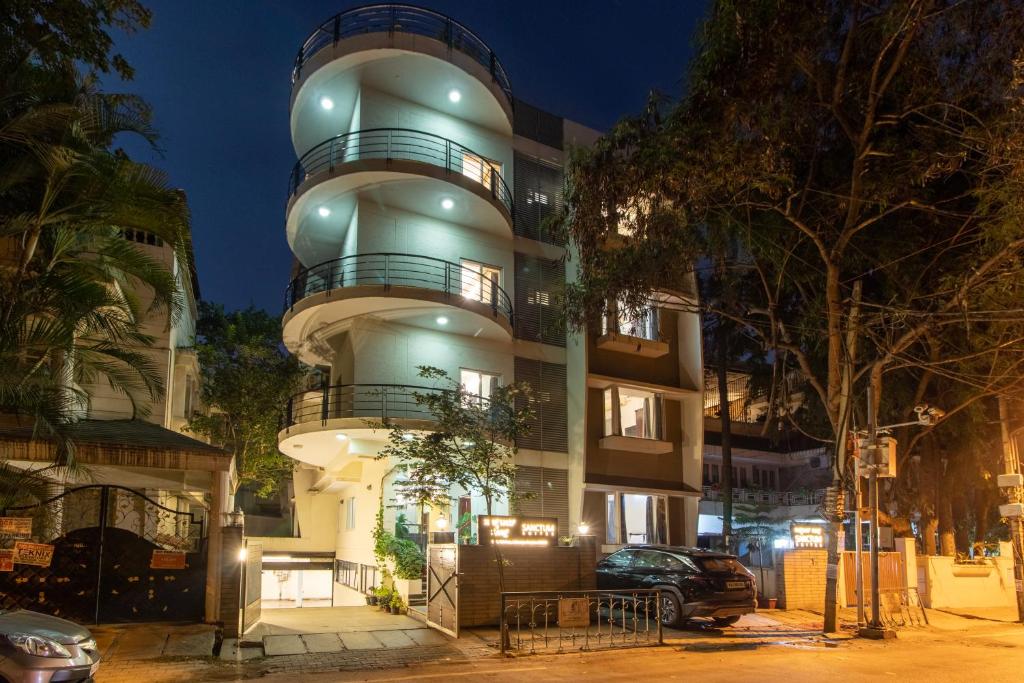 een gebouw waar een auto voor geparkeerd staat bij Sanctum Suites Indiranagar Bangalore in Bangalore