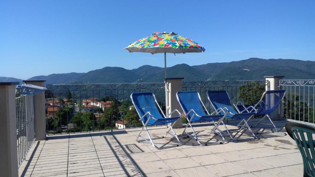 a group of chairs and an umbrella on a balcony at Cinque Terre Tra Il Filo Di Arianna in Riccò del Golfo di Spezia