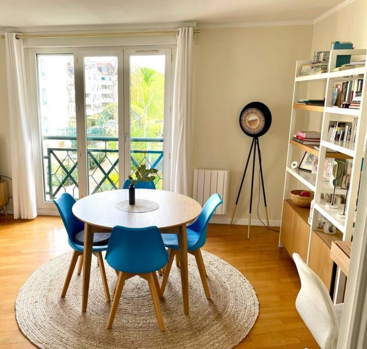 une salle à manger avec une table et des chaises bleues dans l'établissement Charming appartment nearby Paris - JO 2024, à Rueil-Malmaison
