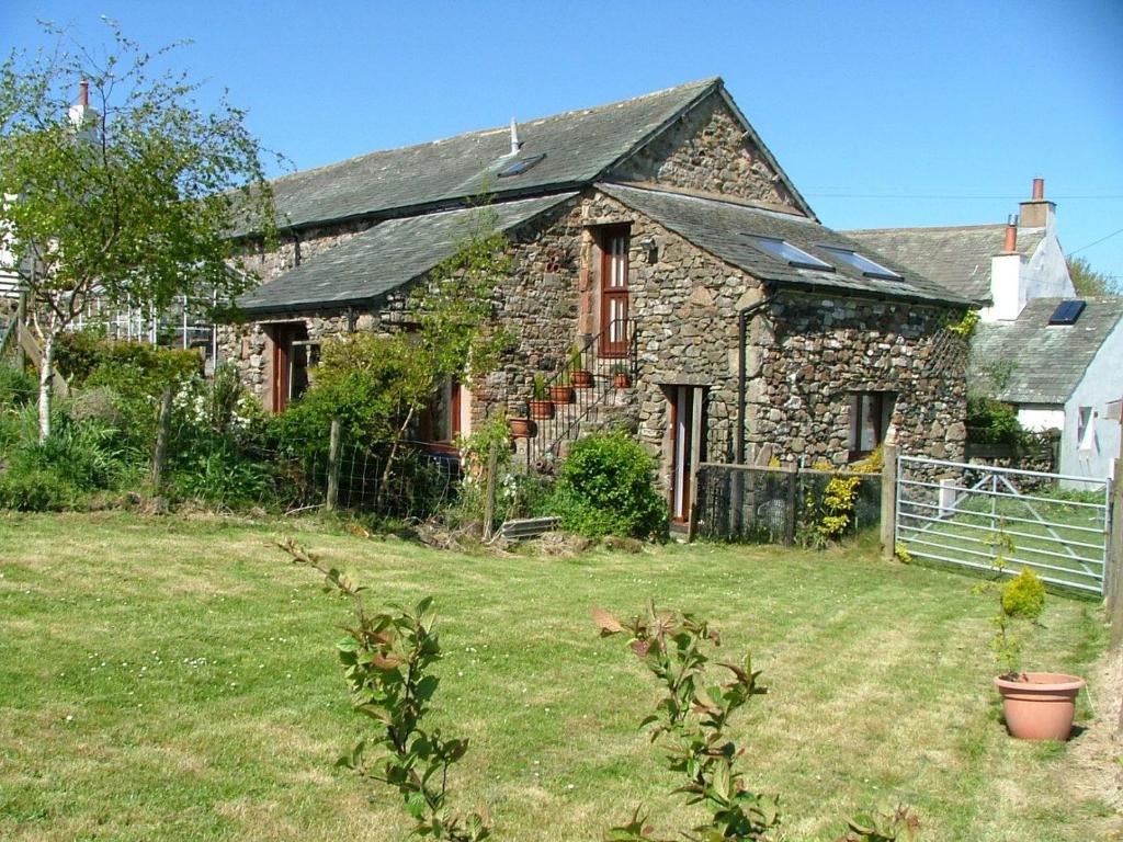 an old stone house with a yard in front of it at The Granary Ruthwaite in Uldale