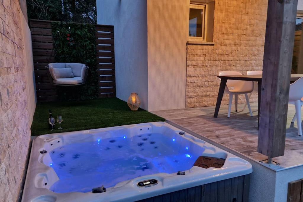 un bain à remous dans une arrière-cour avec une table dans l'établissement Petite maison - Porto-Vecchio, à Porto-Vecchio
