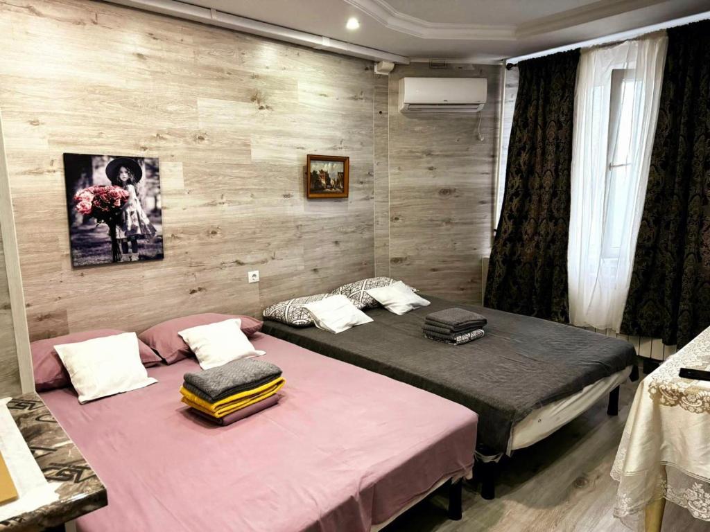 2 aparte bedden in een kamer met houten wanden bij Smart Apartment in Chişinău