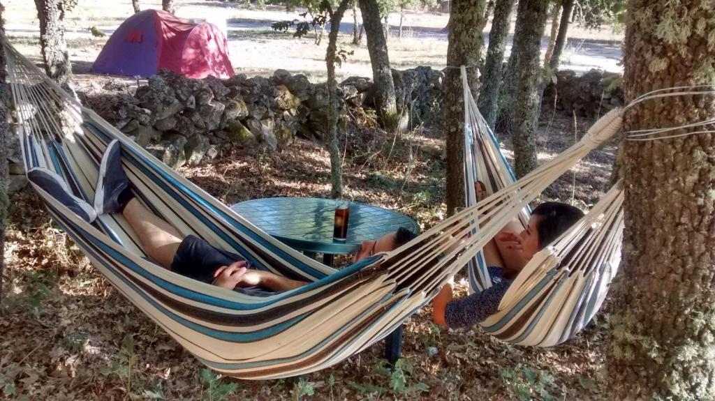 アルデアダビラ・デ・ラ・リベラにあるLas Casitas de las Arribesの森の中のハンモックに寝転がる二人
