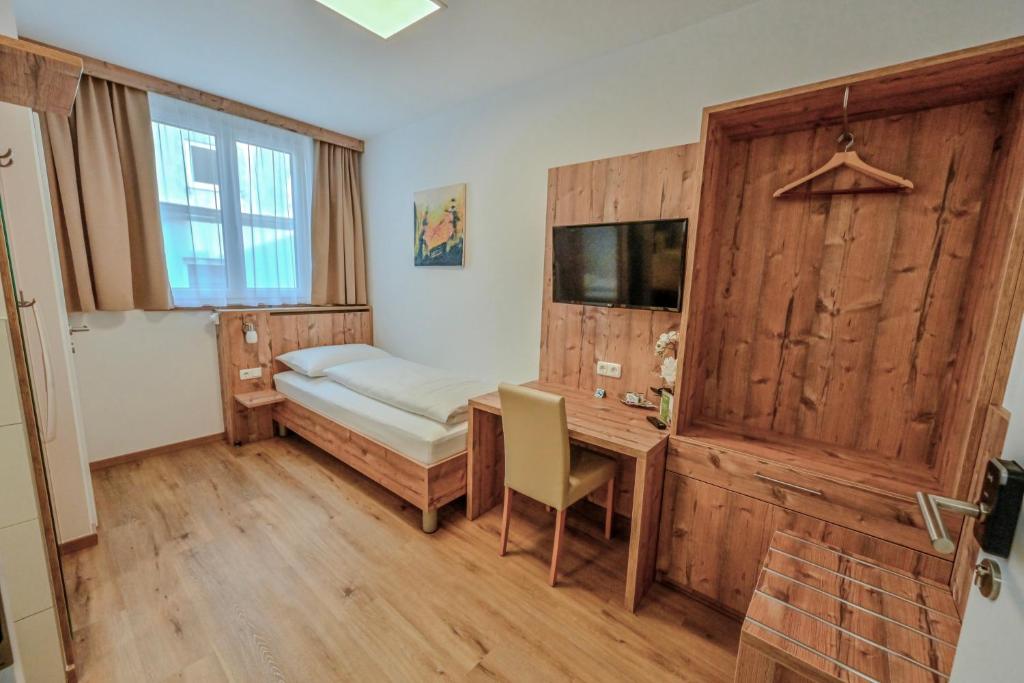 a room with a bed and a desk and a window at City Rooms Wels - contactless check-in in Wels