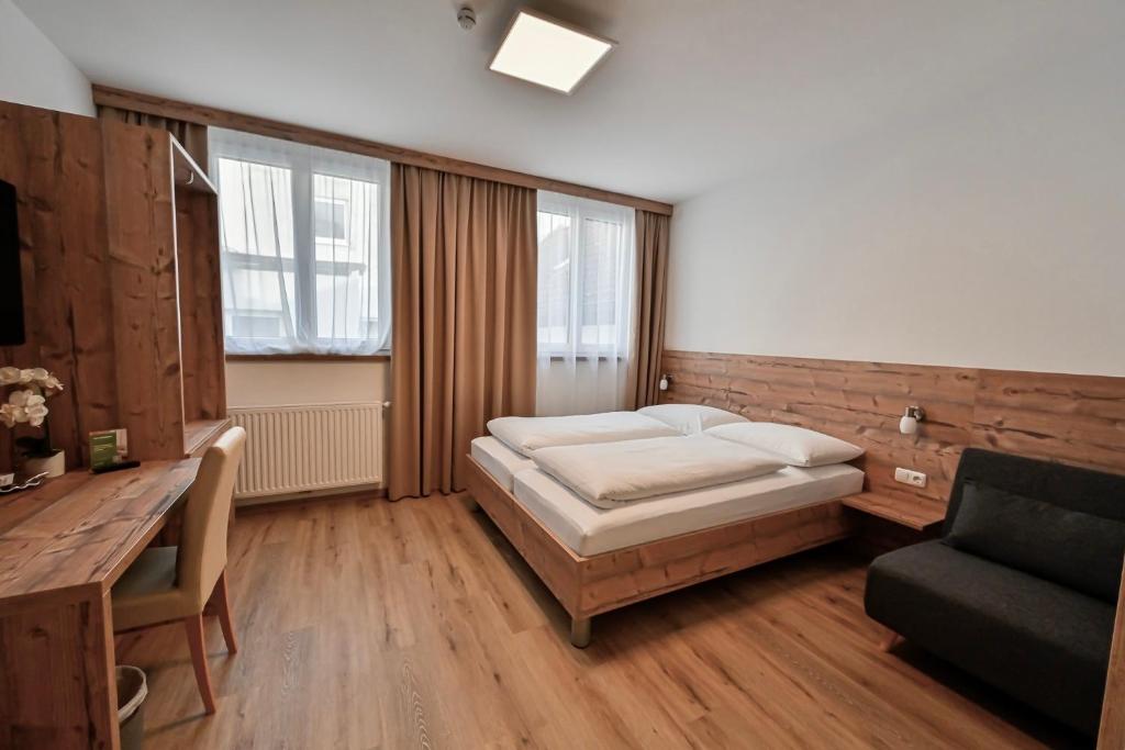 a bedroom with a bed and a desk and a chair at City Rooms Wels - contactless check-in in Wels