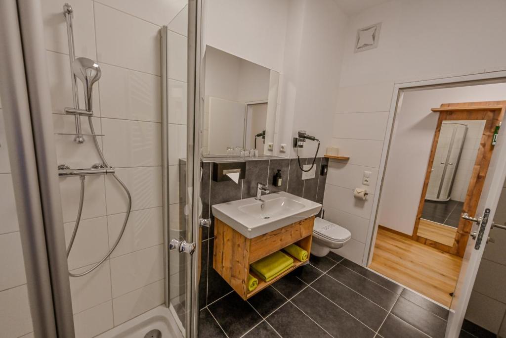 a bathroom with a sink and a shower and a toilet at City Rooms Wels - contactless check-in in Wels