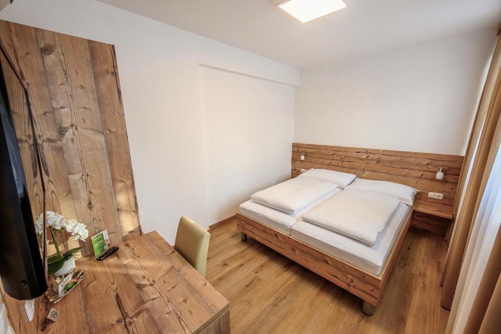 a small bedroom with a bed and a table at City Rooms Wels - contactless check-in in Wels