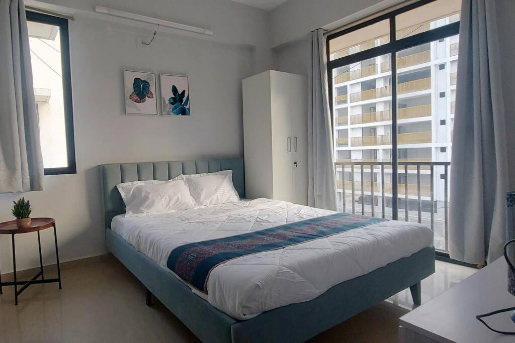 ガンディーナガルにあるVIAAN Penthouse 1 BHK with terraceのベッドと大きな窓のある寝室