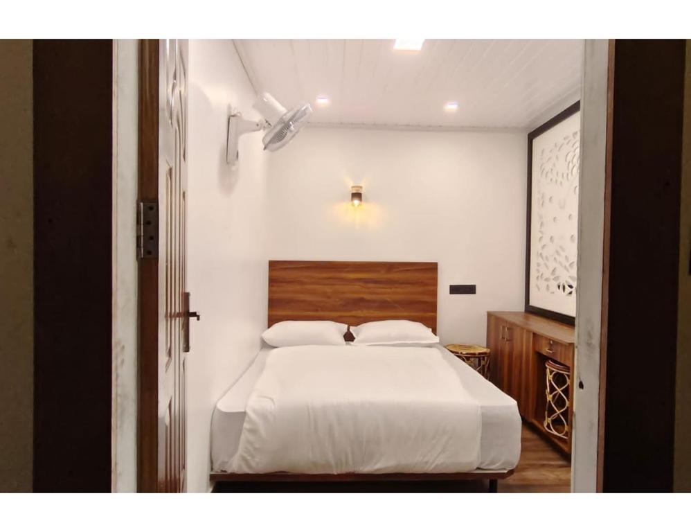 Un pat sau paturi într-o cameră la Birdwing Cottage, Munnar