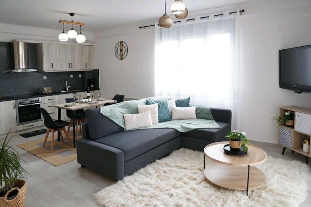 uma sala de estar com um sofá azul e uma cozinha em Boutique lazou em Neochorópoulon