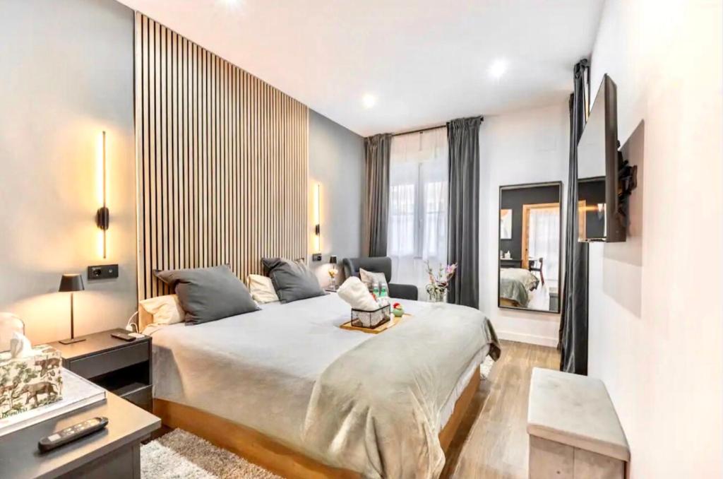 a bedroom with a large bed and a living room at Luxury and elegant apartment Madrid in Madrid
