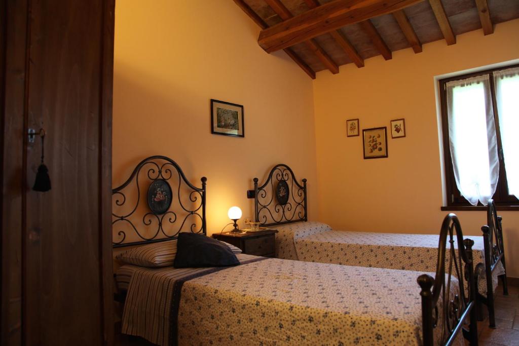 a bedroom with two beds and a window at Agriturismo Biologico Villa Rosa in Monte Guiduccio