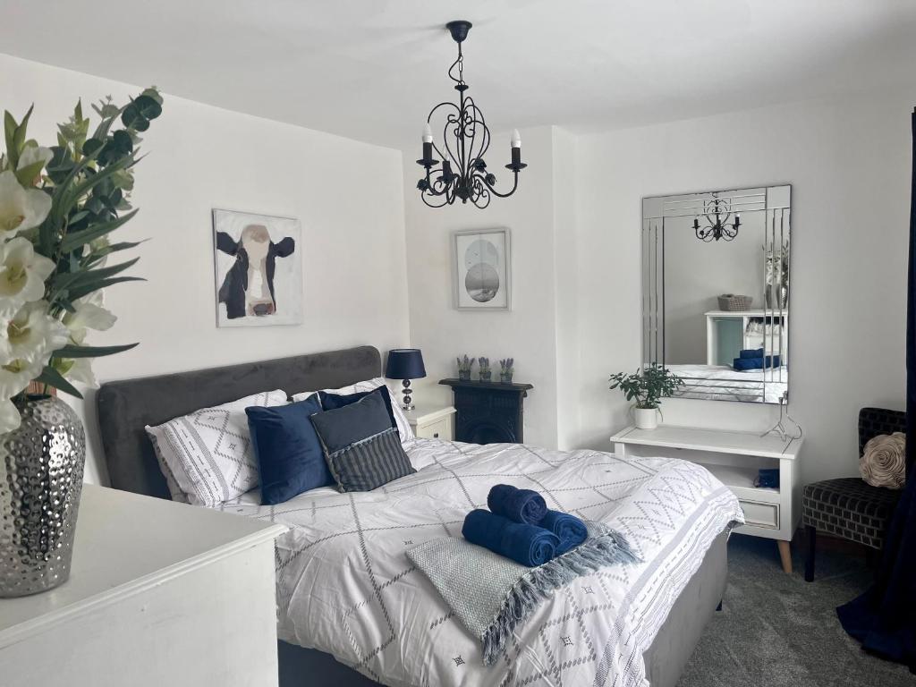 een slaapkamer met een bed met blauwe kussens erop bij Village Escape in Messingham