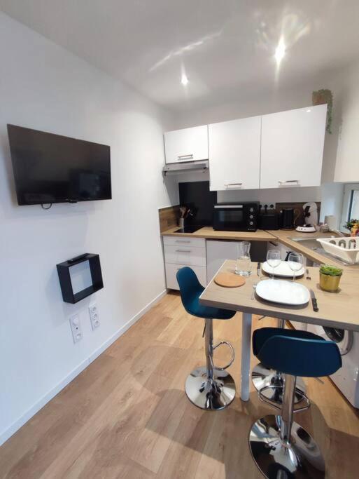 une cuisine avec une table et des chaises dans une pièce dans l'établissement La petite bascule, à Orléans