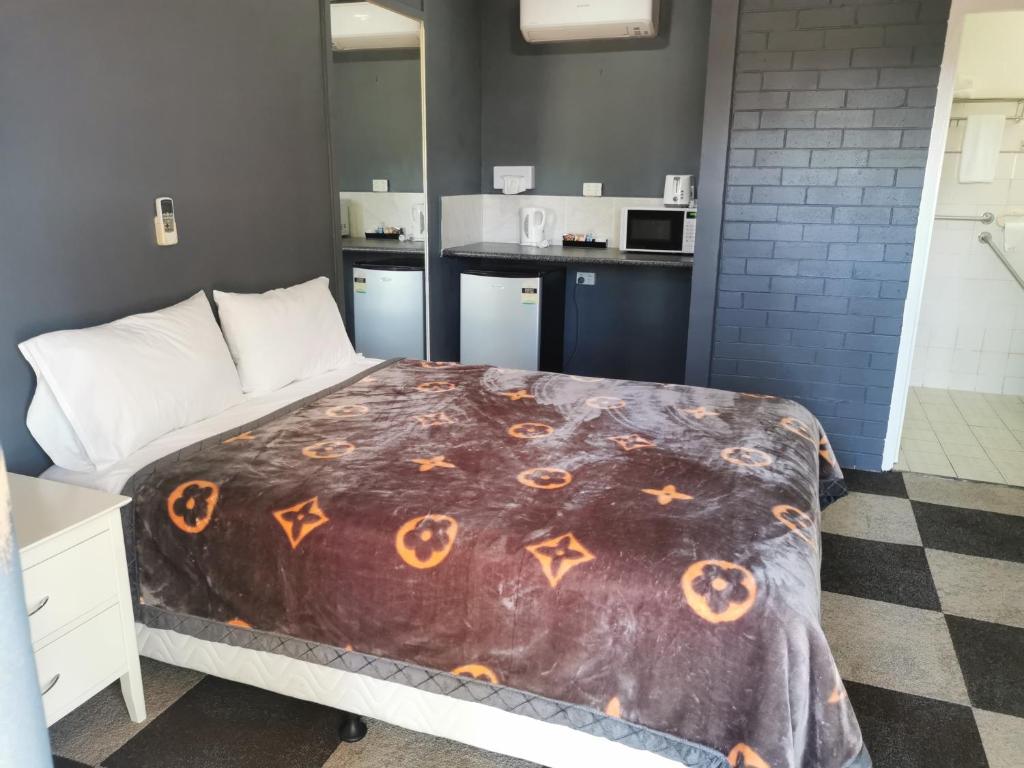 Un dormitorio con una cama con calabazas. en All Seasons Country Lodge, en Taree