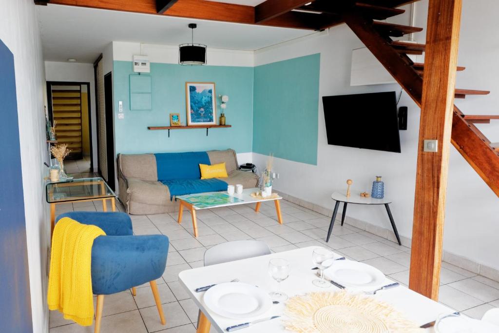 un soggiorno con divano e tavolo di Appart' Bleu Soleil a Filaos