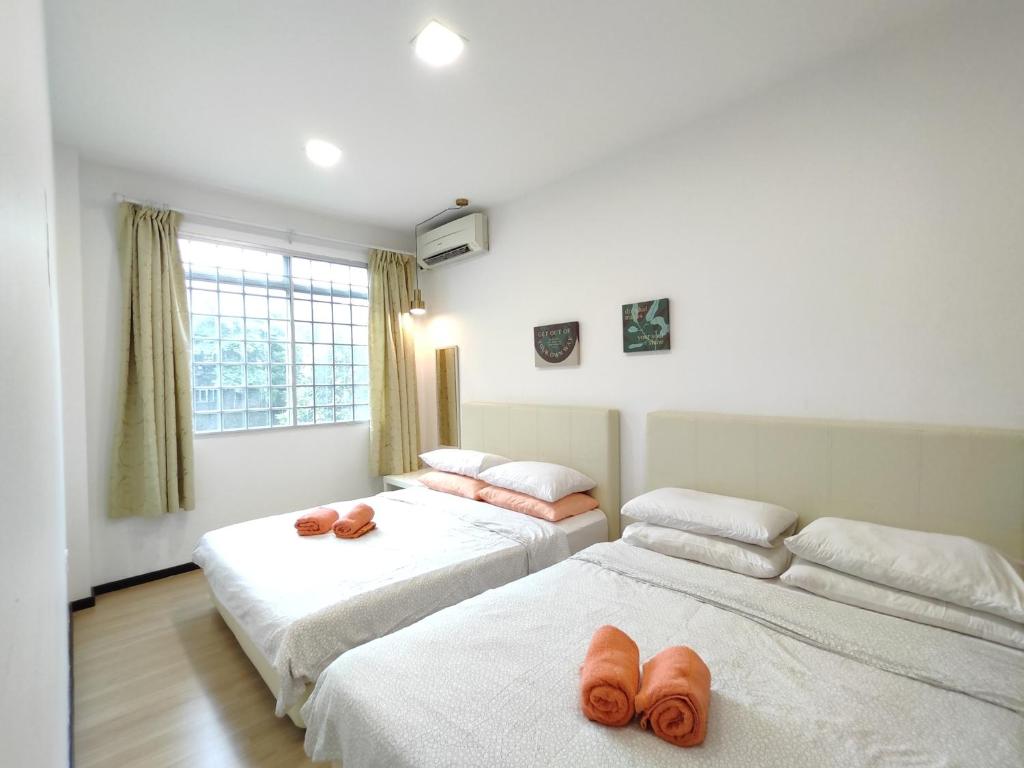 a bedroom with two beds with towels on them at Eden 8pax 3Rooms apartment near Kuching Airport in Kuching