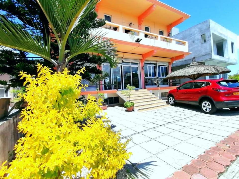a red car parked in front of a house at Sun & Earth Villa in Mont Choisy