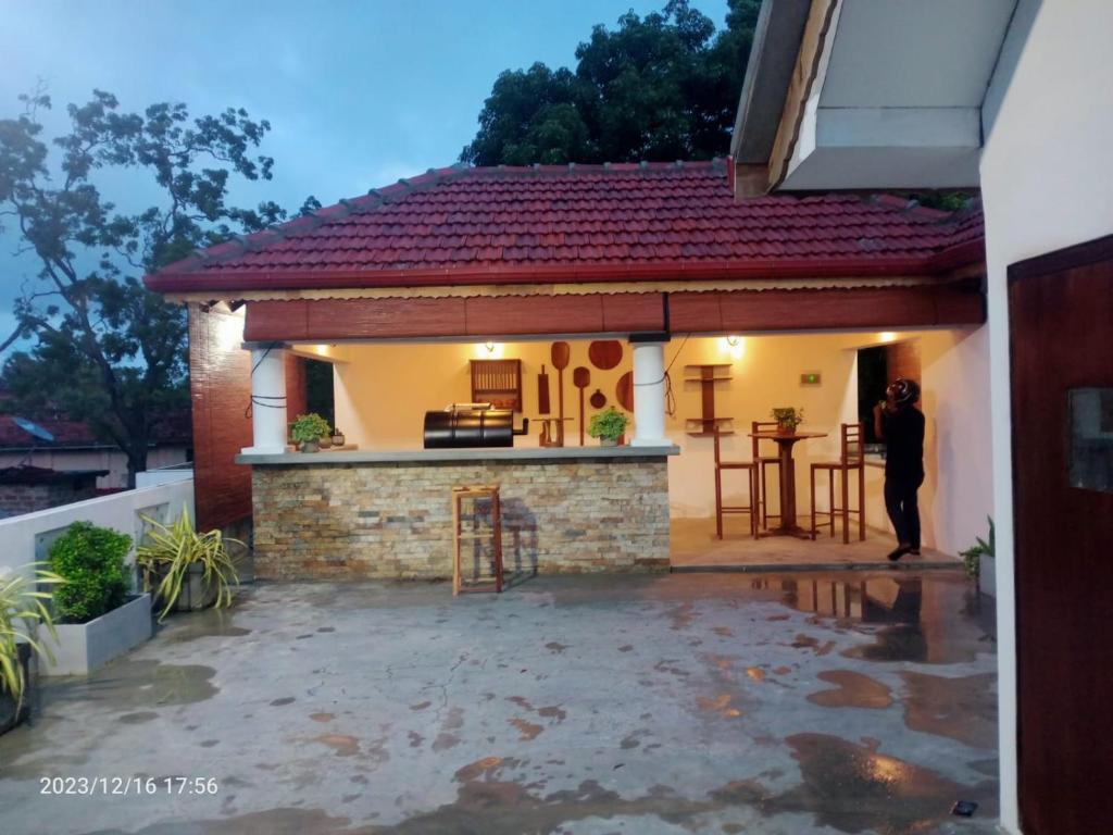 a person standing outside of a small house at Gunam Residence in Kattankudi