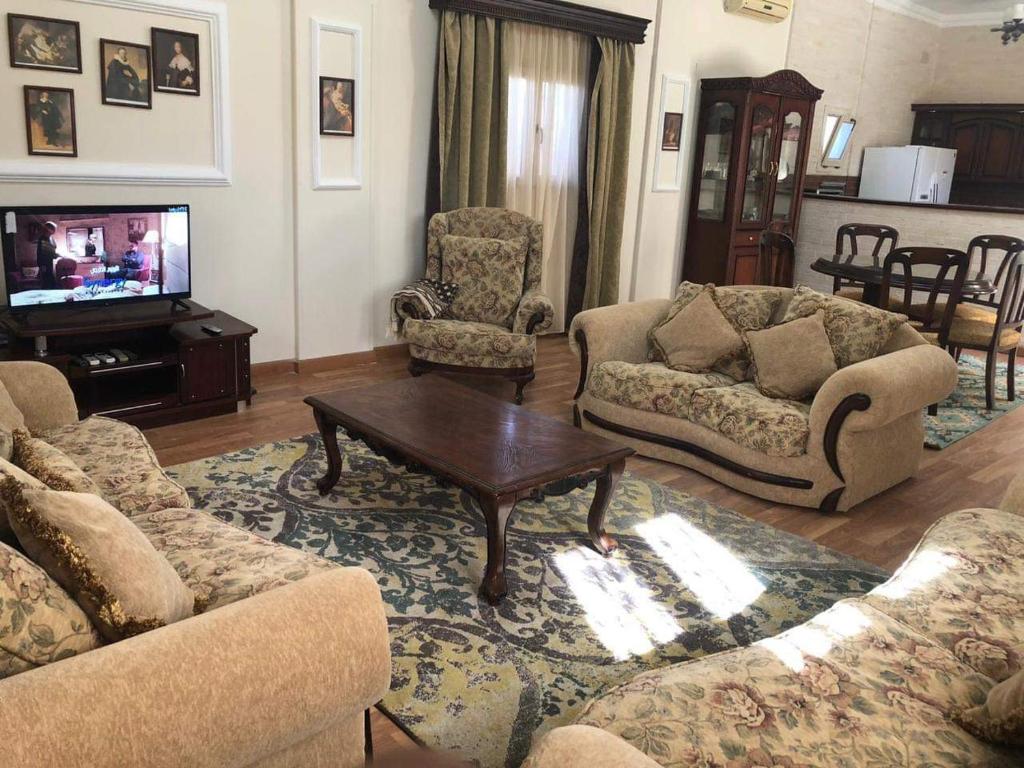 ein Wohnzimmer mit einem Sofa und einem Couchtisch in der Unterkunft Beautiful private villa Magawhish in Hurghada