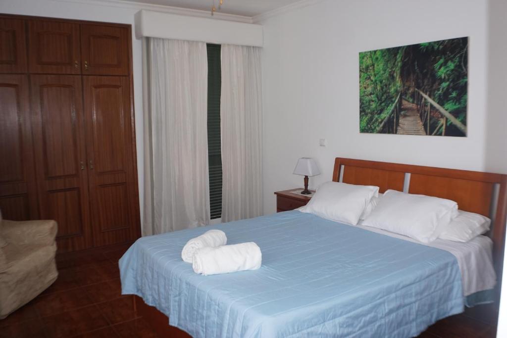 a bedroom with a blue bed with towels on it at !Your Home In Madeira in Funchal