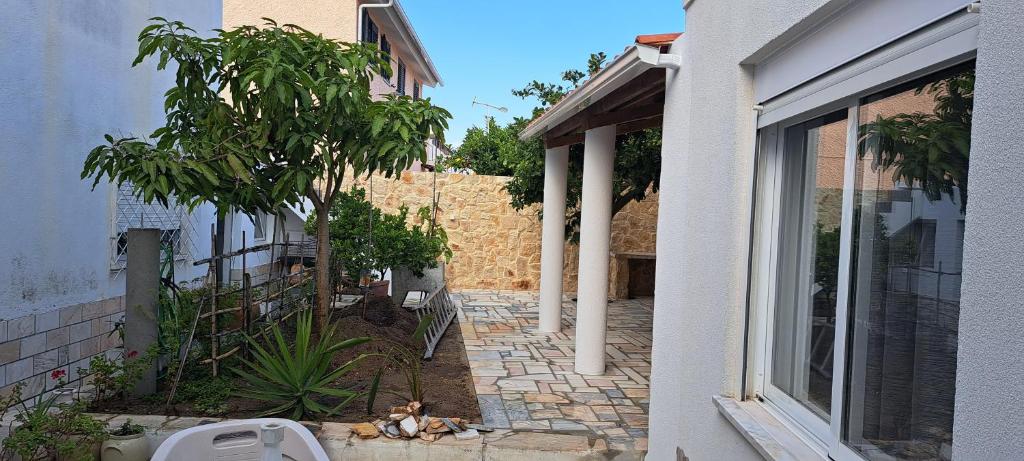 a courtyard of a house with a tree and a window at appartement in Charneca