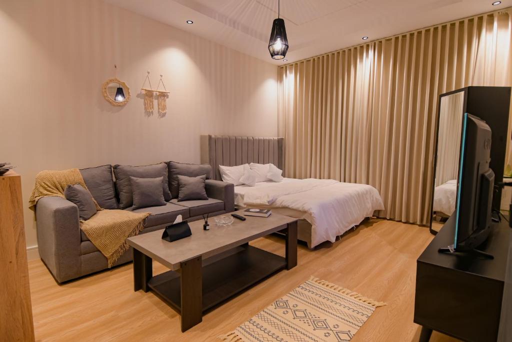uma sala de estar com um sofá e uma cama em استديو مودرن بمدخل ذاتي بجانب البوليڤارد em Riyadh