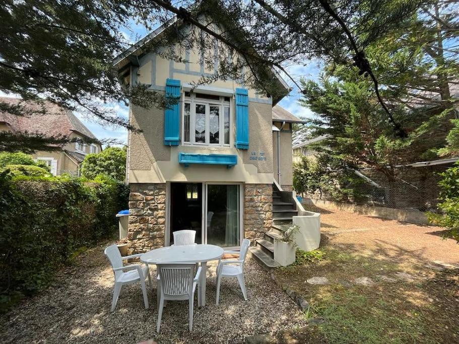 une table et des chaises devant une maison dans l'établissement Maison à 100 m de la plage et proche du centre, à Jullouville
