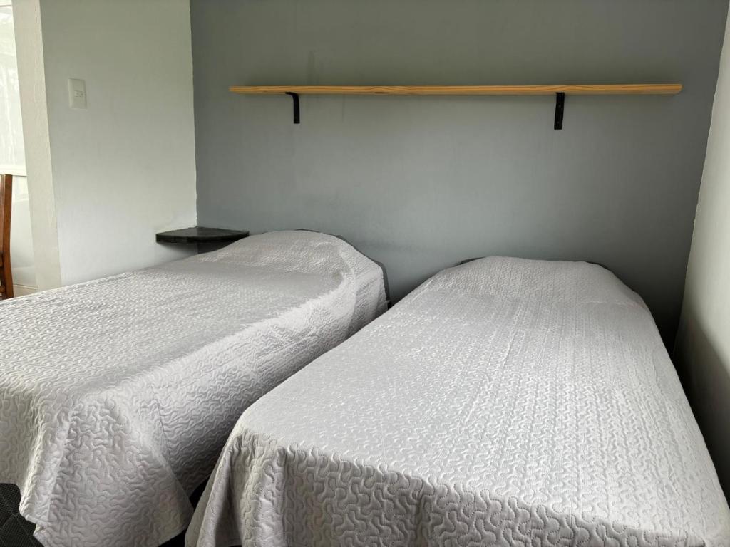 コロニア・デル・サクラメントにあるComplejo Las Palmerasのベッド2台が隣同士に設置された部屋です。