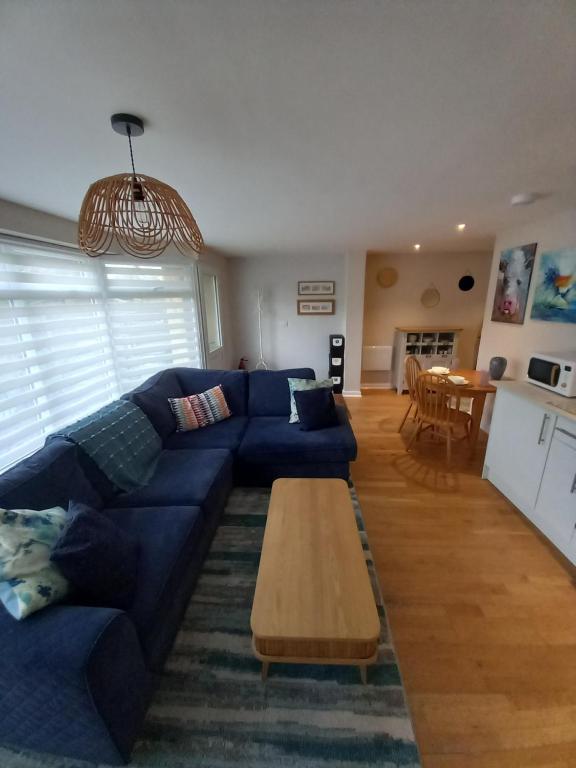 a living room with a blue couch and a table at Laurel Apartment in Bourton on the Water