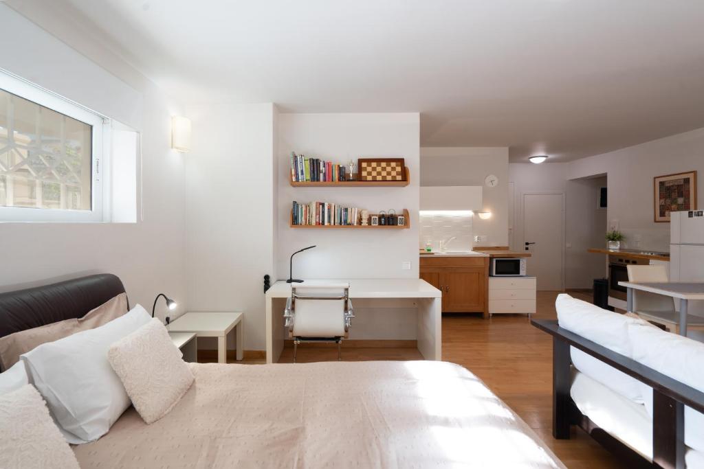 salon z łóżkiem i biurkiem oraz kuchnię w obiekcie Bright, Cosy Studio close to Glyfada Beach & Center w Atenach