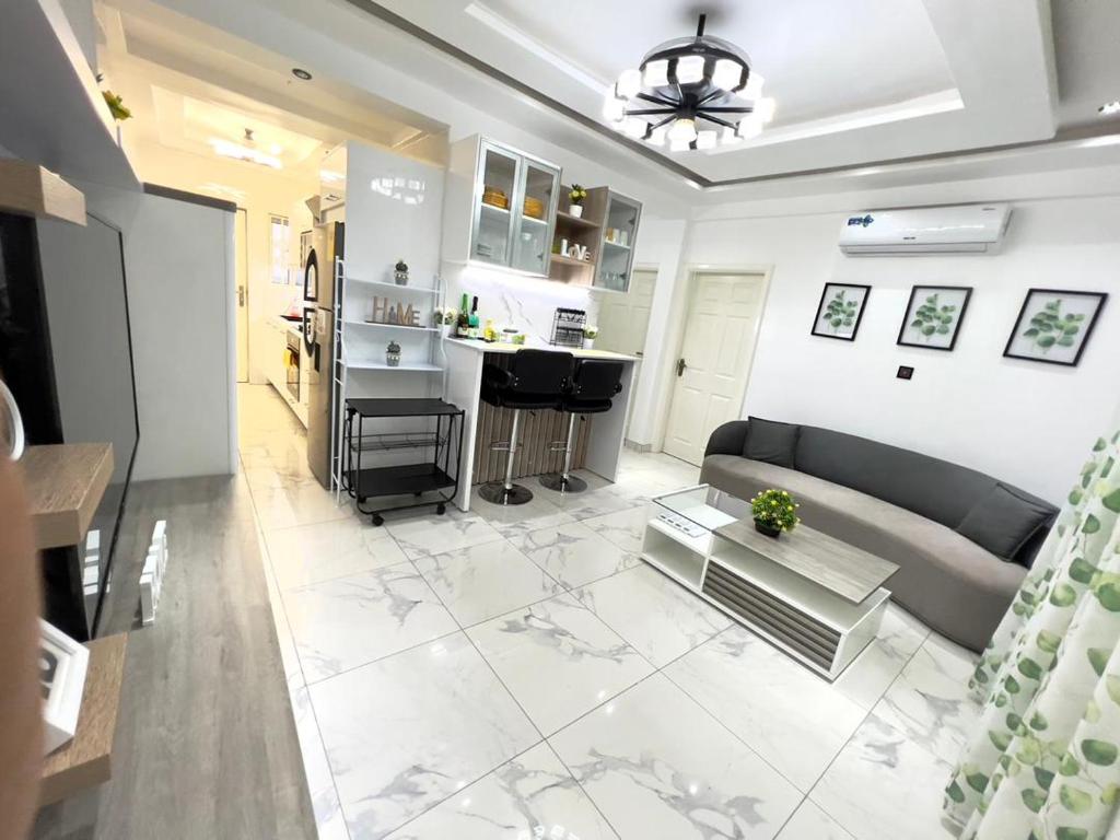 uma sala de estar com um sofá e uma cozinha em Precious Palace em Acra