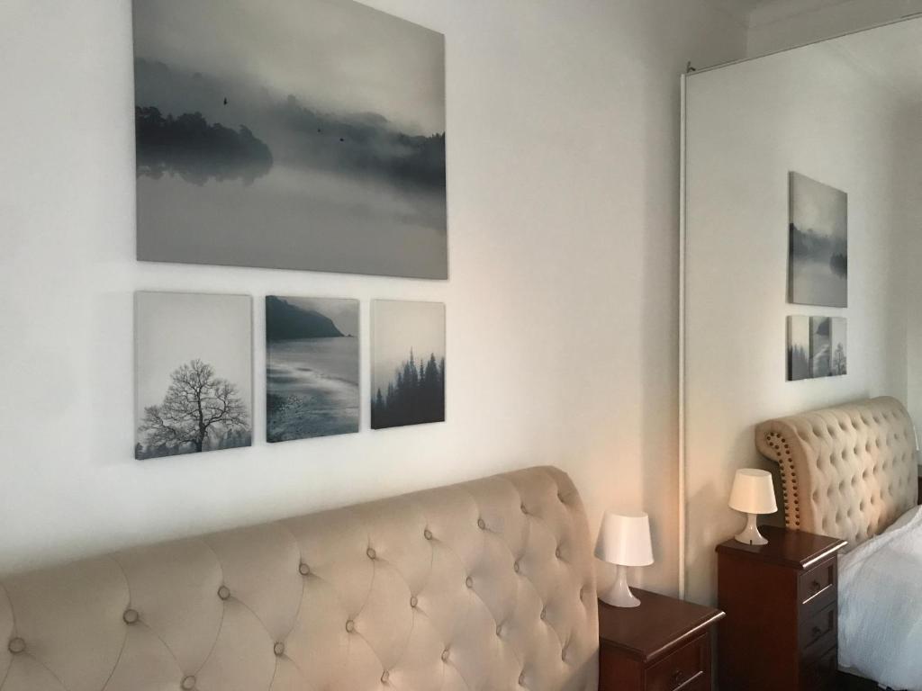 a hotel room with a couch and pictures on the wall at Appartamento 5 stelle in Piazza Asti - Re di Roma - in Rome