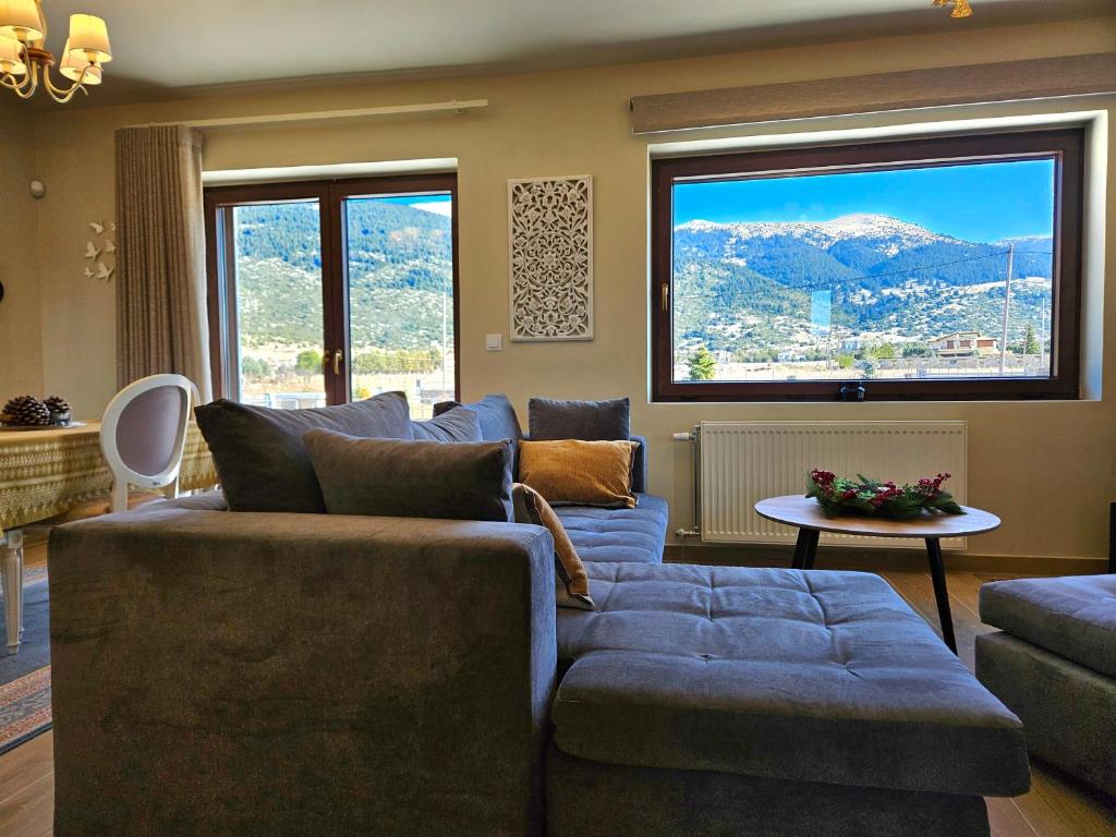 - un salon avec un canapé bleu et une grande fenêtre dans l'établissement Kallisto villas, à Kalívia