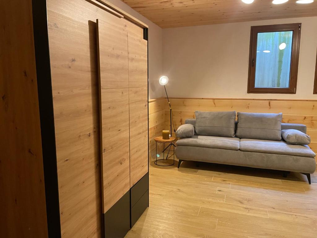 uma sala de estar com um sofá e uma janela em Golfchalet 3 confini em Tarvisio