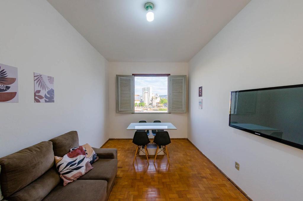 a living room with a couch and a large flat screen tv at Apto 3qts centro - vista cartão postal in Belo Horizonte