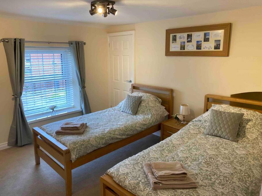 una camera da letto con due letti e una finestra di 43 Heol Maelor- A Homely Cottage in Wrexham, North Wales a Coedpoeth