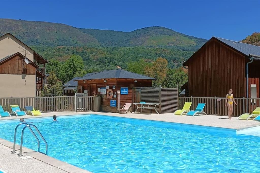 - une piscine avec des chaises, une maison et des montagnes dans l'établissement L'APPARTEMENT DE NOAH appartement Rez de chaussée classé 2 étoiles avec terrasse, à Ax-les-Thermes