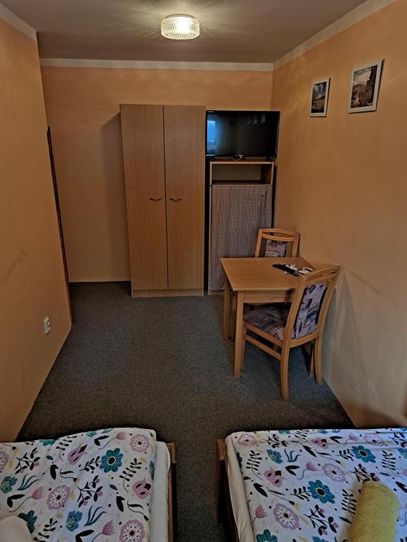 a small room with two beds and a table and a tableablish at U Bernardýna in Harrachov