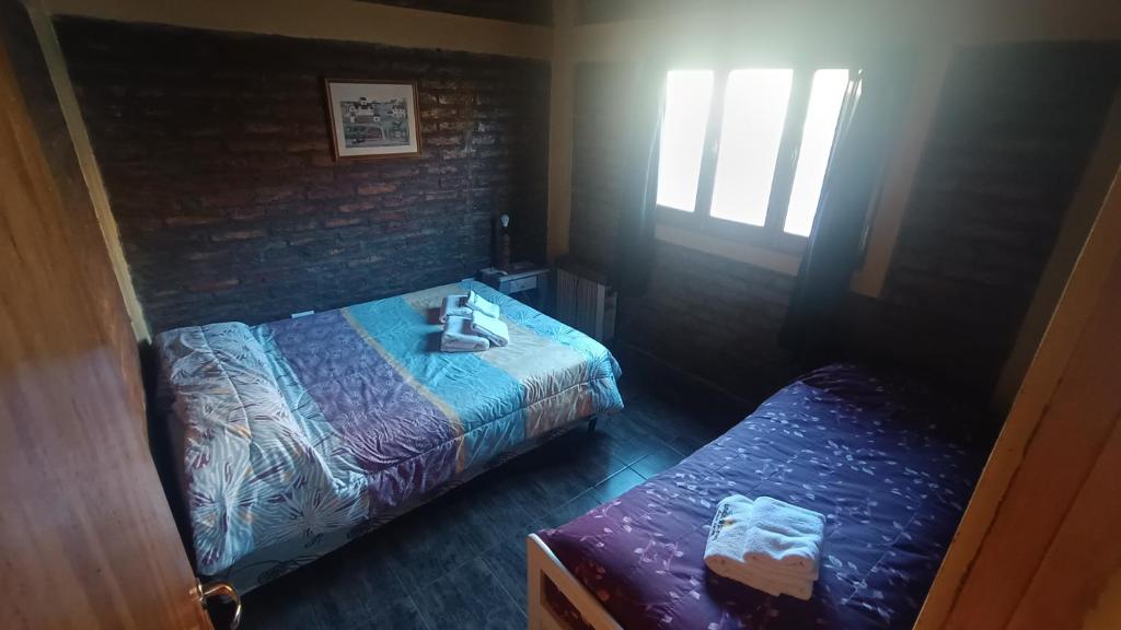1 dormitorio con 2 camas y ventana en Cabañas de los Andes en Uspallata