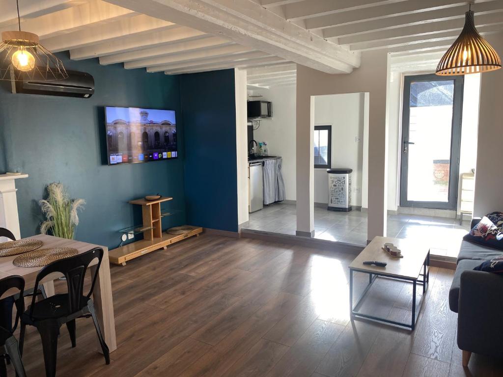 a living room with a table and a couch at Jolie petite maison solognote in Pierrefitte-sur-Sauldre