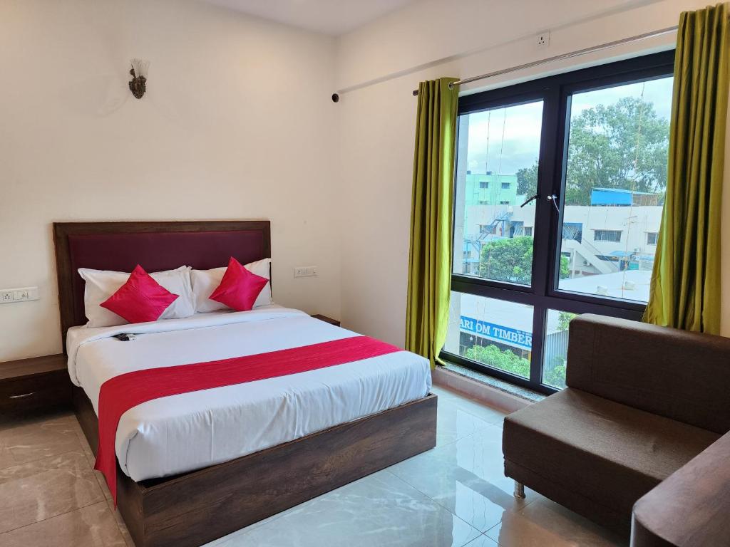 a bedroom with a bed and a large window at Hotel ksp kings inn in Bangalore