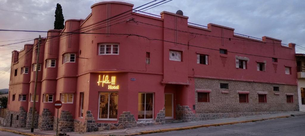 ein rotes Gebäude auf der Straßenseite in der Unterkunft Holâ Hotel in La Falda