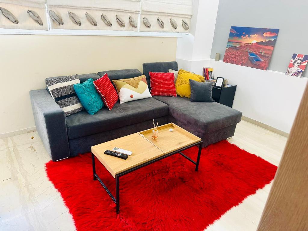 a living room with a gray couch with colorful pillows at ROYAL RED SUITE NO 1, PIRAEUS PORT in Piraeus