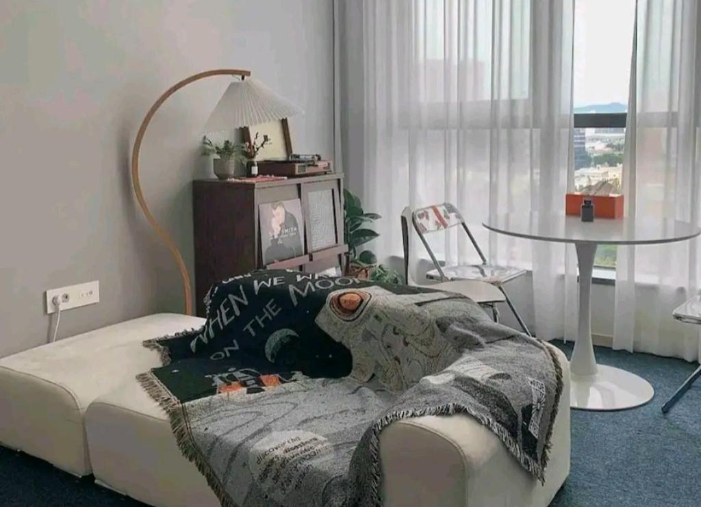 ソウルにあるCoex Stayのリビングルーム(ベッド1台、テーブル、窓付)