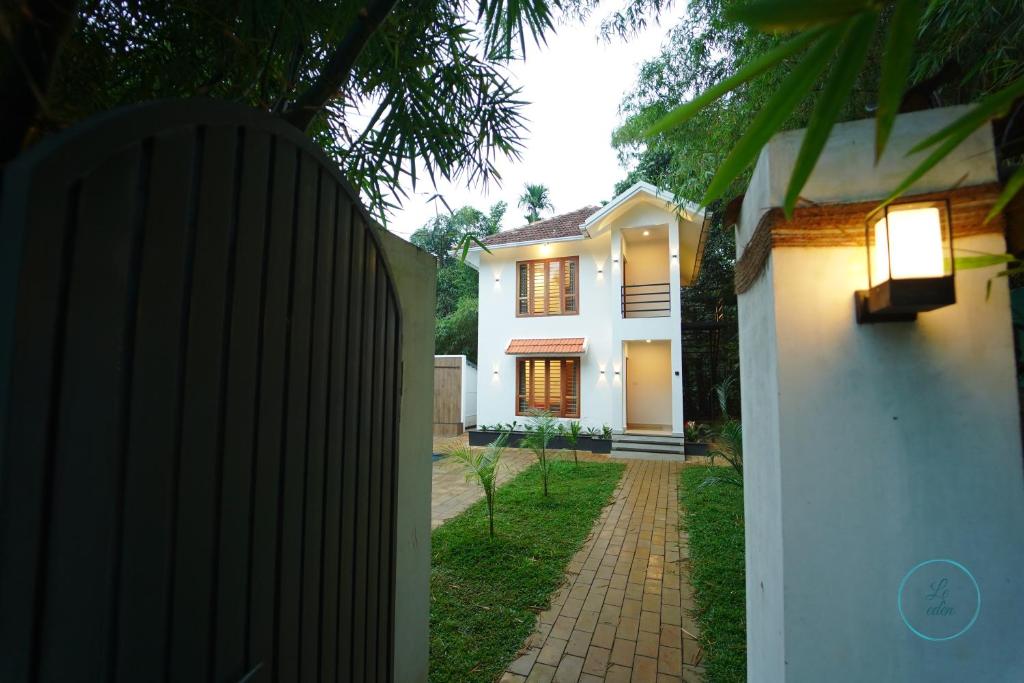une maison blanche avec une clôture devant elle dans l'établissement Le Eden Resort, à Sultan Bathery